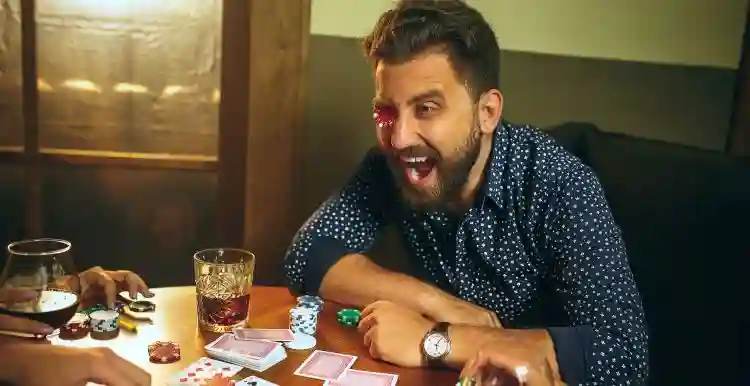 Filmes Sobre Apostas E Jogos de Azar Que Não Pode Perder 2 20240718 funny male female friends sitting wooden table men women playing card game hands with alcohol close up